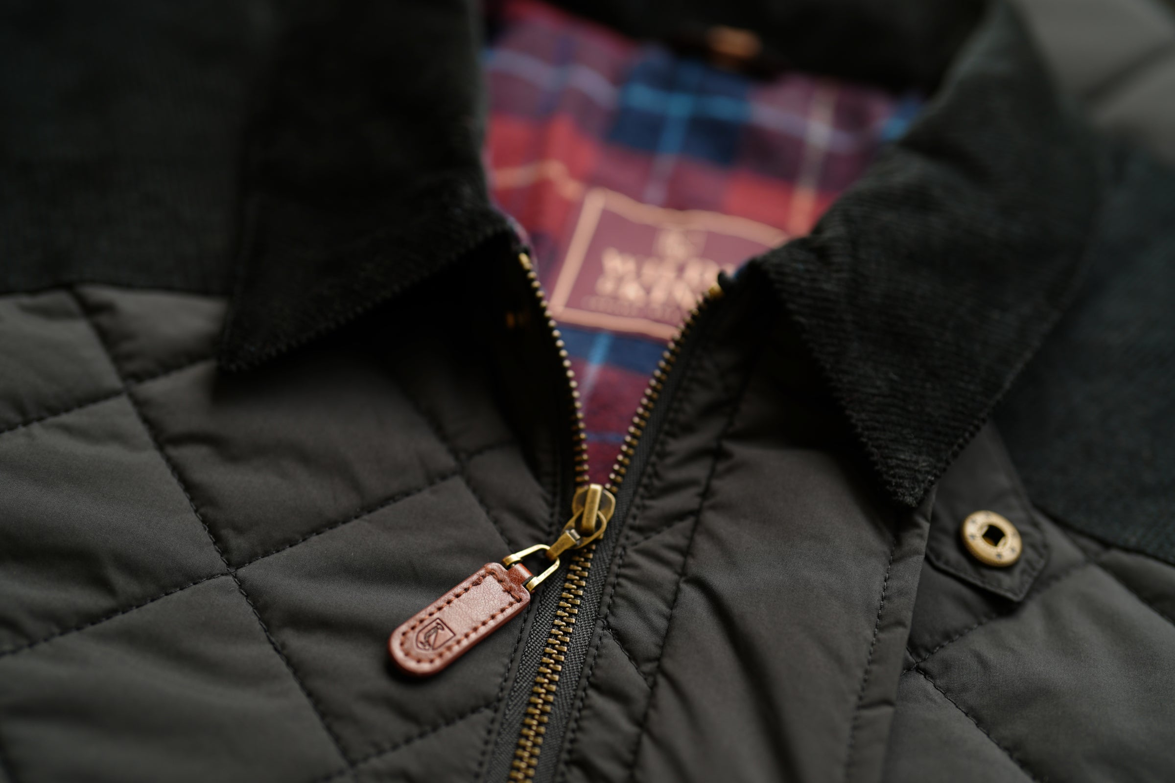 Black quilted jacket with plaid lining and a Wilde & King label