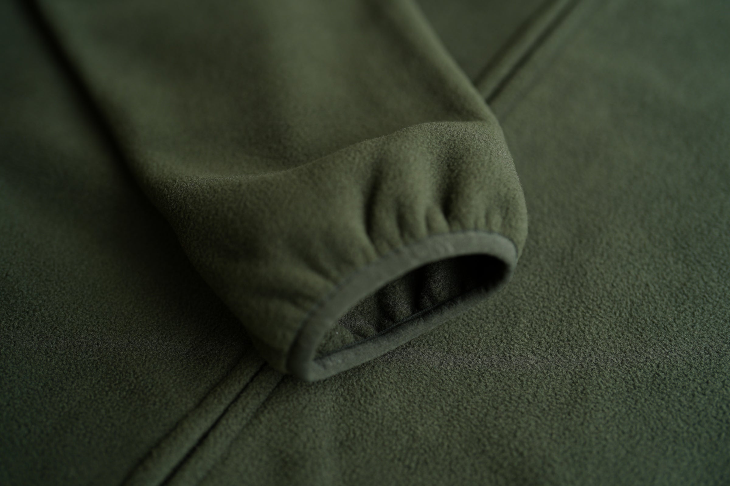 Close-up of a green fleece sleeve with an elastic cuff