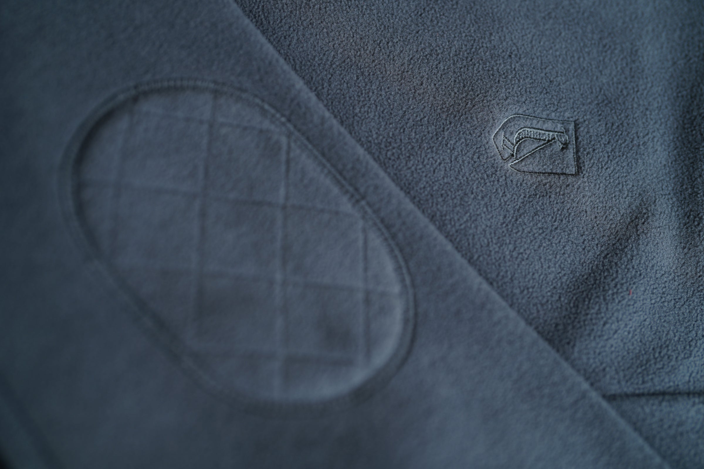 Blue fleece fabric with a Wilde & King logo and an elbow patch detail